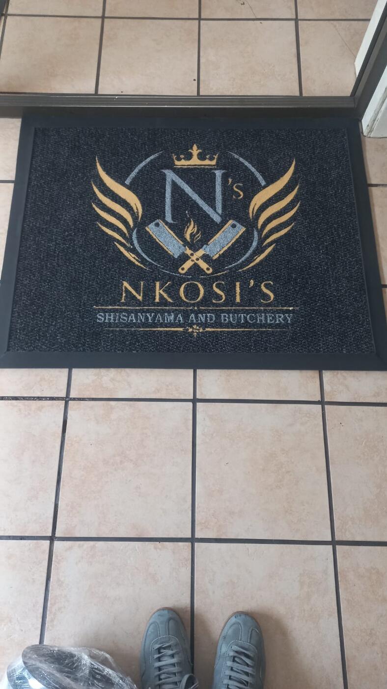 Gold crest logo mat at a restaurant entrance